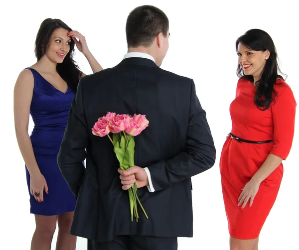 Homem com um buquê de flores e duas jovens mulheres — Fotografia de Stock