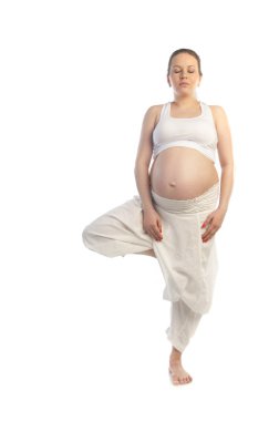 Beautiful pregnant woman doing yoga exercise. clipart