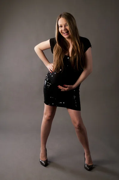 Jonge mooie zwangere vrouw in zwarte jurk. — Stockfoto