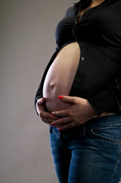 Pregnant woman holding her tummy — Stock Photo, Image