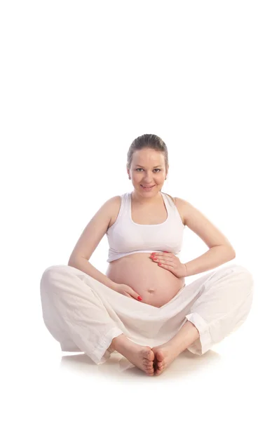Беременная женщина прикасается руками к животу — стоковое фото