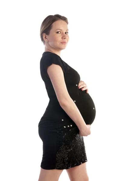 Junge schöne schwangere Frau im schwarzen Kleid. — Stockfoto