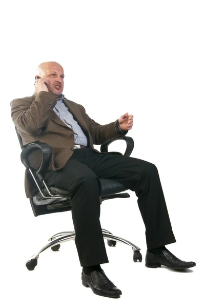 Бізнесмен розмовляє по телефону, сидячи в кріслі . — стокове фото