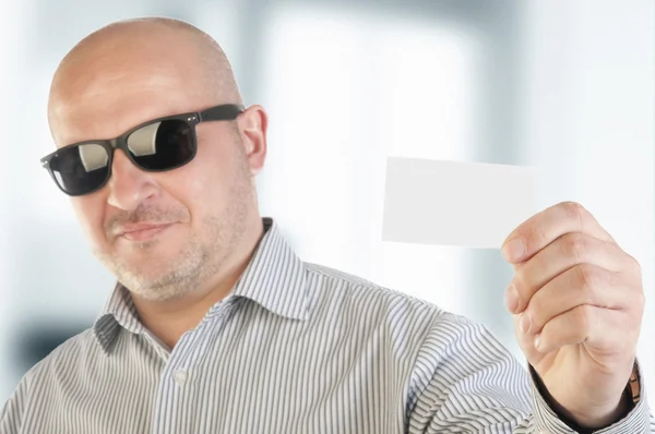 Empresário segurando um cartão comercial em branco . — Fotografia de Stock