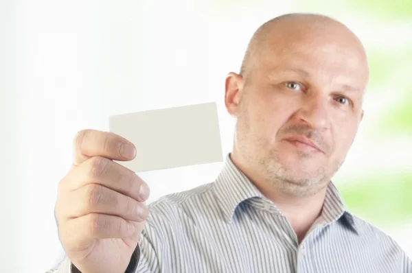 Empresário segurando um cartão comercial em branco — Fotografia de Stock