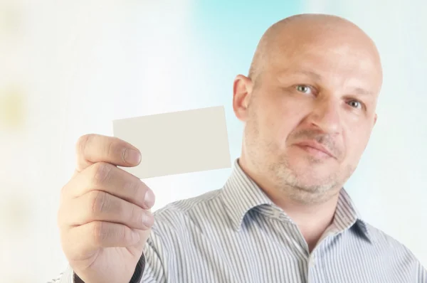 Empresário segurando um cartão comercial em branco — Fotografia de Stock