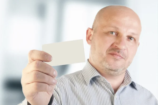 Affärsman som innehar ett tomt visitkort — Stockfoto