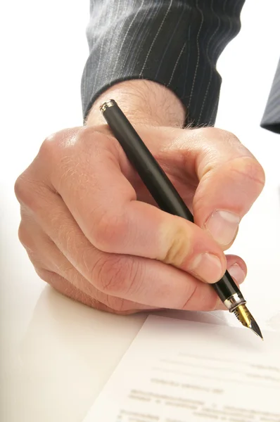 Человеческая рука с ручкой делает подпись — стоковое фото
