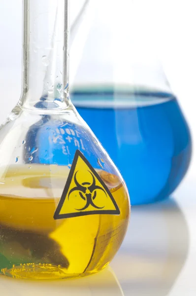 Gläserne Laborgeräte mit Symbol Biohazard — Stockfoto