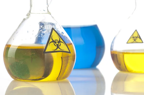 Glass laboratory equipment with symbol biohazard — Stock Photo, Image