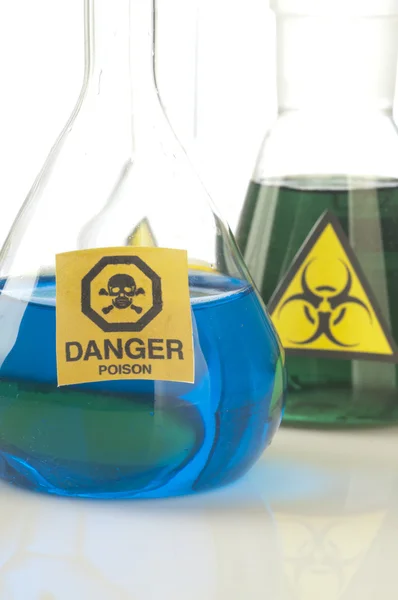 Glass laboratory equipment with symbol biohazard and danger — Stock Photo, Image