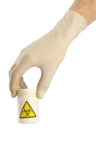 Hand holds jar of medicament with symbol biohazard.
