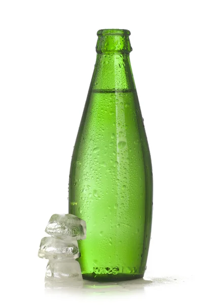 Зеленая стеклянная бутылка минеральной воды со льдом — стоковое фото