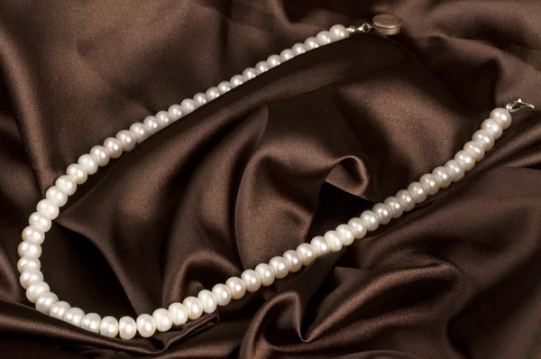 Pärlor ett halsband på en sidenväv — Stockfoto