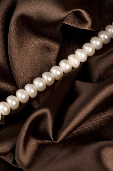 Perlen eine Kette auf einem Seidenstoff — Stockfoto