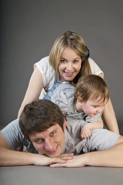 Izgatott, boldog fiatal család egy örömteli zűrzavar — Stock Fotó