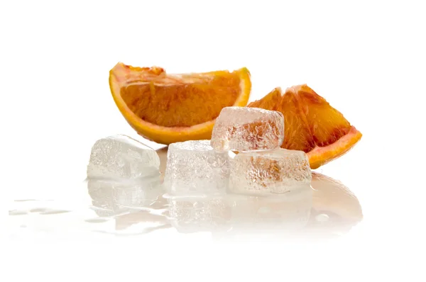Кубики льда, расплавленные в воде и ломтики апельсина — стоковое фото