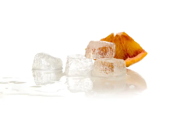Es batu meleleh dalam air dan irisan oranye — Stok Foto
