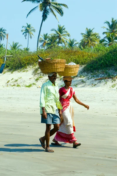 Stock image Woman ana man with full dish on the head on a beach