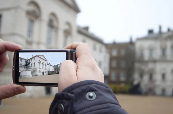Tourist Holds Up Camera Phone at Nelson's monument — Stock Photo, Image