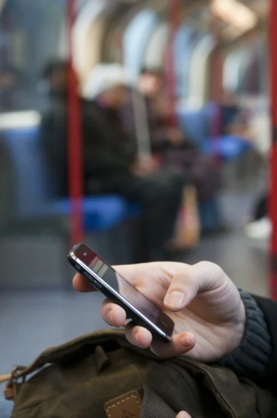 Una persona con un teléfono en el metro —  Fotos de Stock