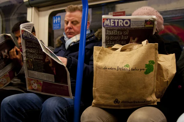 In London Underground train reading the morning newspaper — Stock Photo, Image