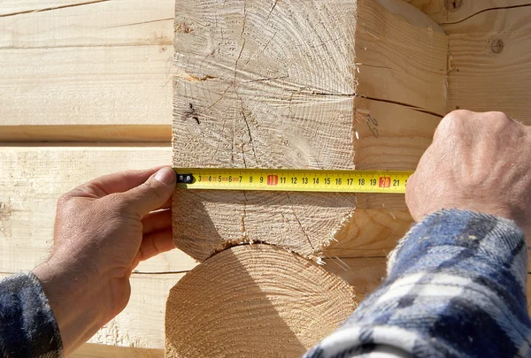 Carpintero mide troncos de madera —  Fotos de Stock