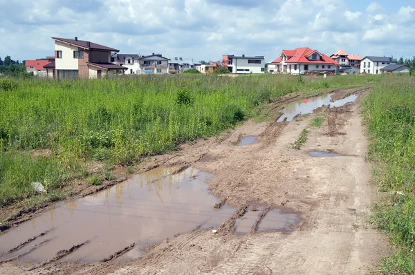 Estrada suja e acidentada que leva à nova área da casa de campo — Fotografia de Stock