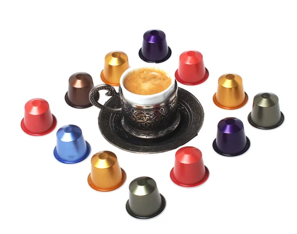 stock image Delicious coffee capsules around coffee cup