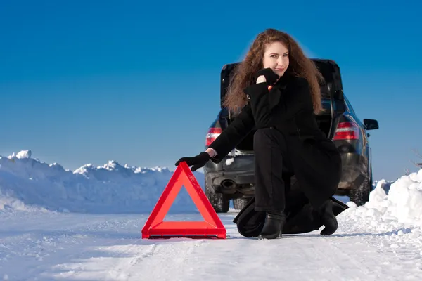 Téli autó bontás - nő gazdaság figyelmeztető háromszög — Stock Fotó