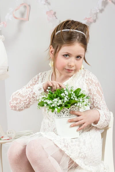 A beautiful little girl with flowers in a pot — Stock Photo, Image