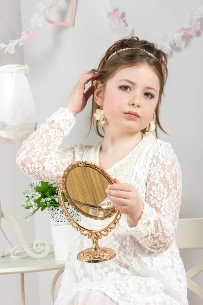 A beautiful little girl looking to small mirror — Stock Photo, Image