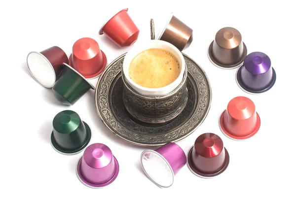 Lahodné kávy kapsle kolem šálek kávy — Stock fotografie