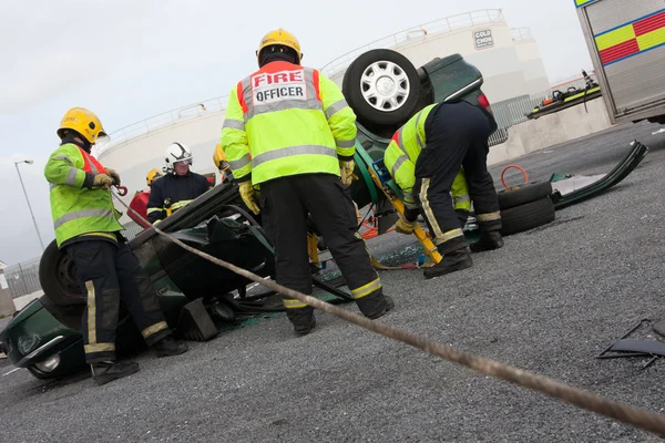 Bomberos y personal de servicio de rescate en la formación de accidentes automovilísticos — Foto de Stock