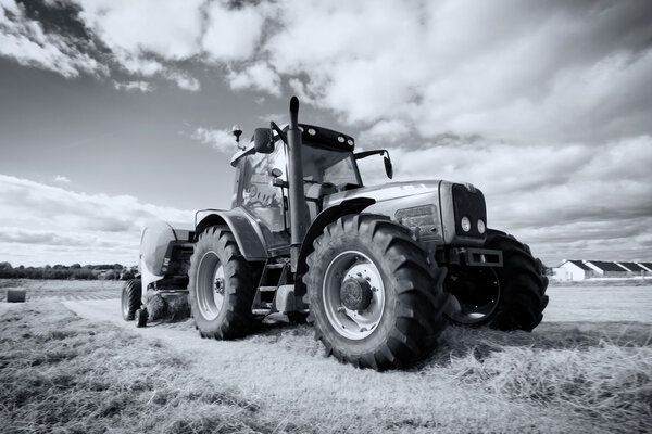 Tractor collecting haystack in the field, panning technique