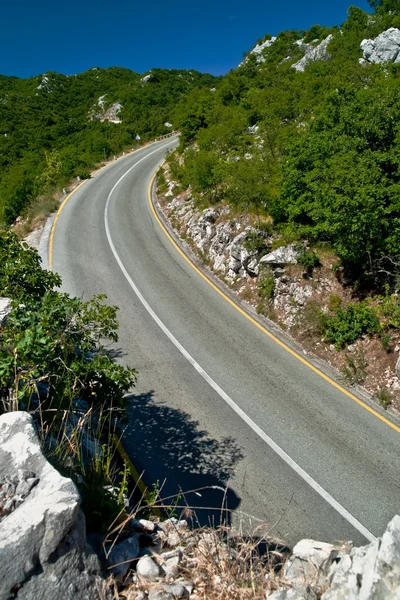 En naturskön och slingrande vägen mellan bergen, vilket leder till toppen — Stockfoto