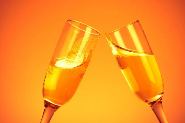 Пара флейт шампанського на помаранчевому фоні — стокове фото