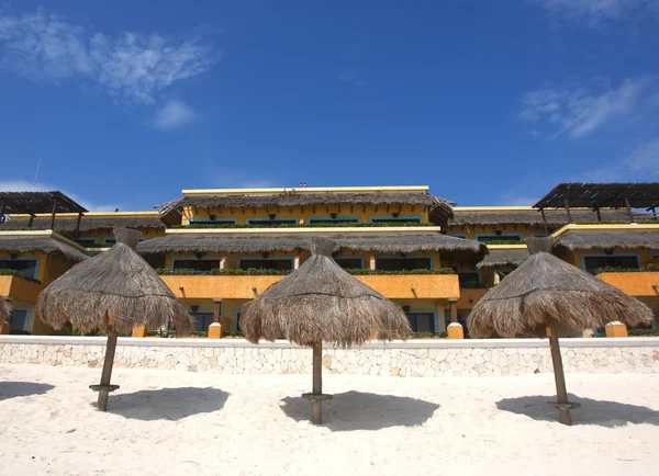Три травяных зонта на курортном пляже — стоковое фото