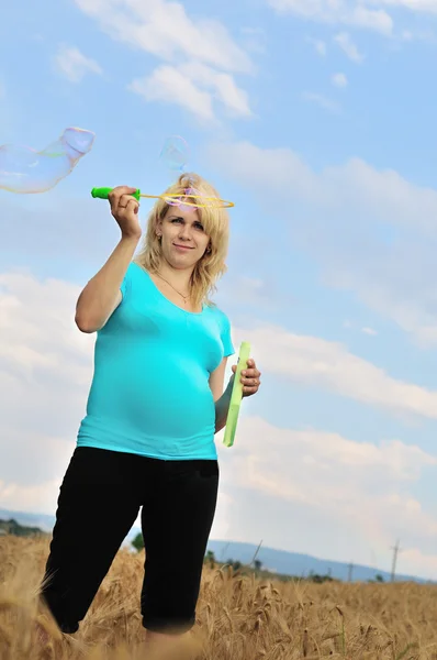 Беременная женщина с мыльными пузырями — стоковое фото
