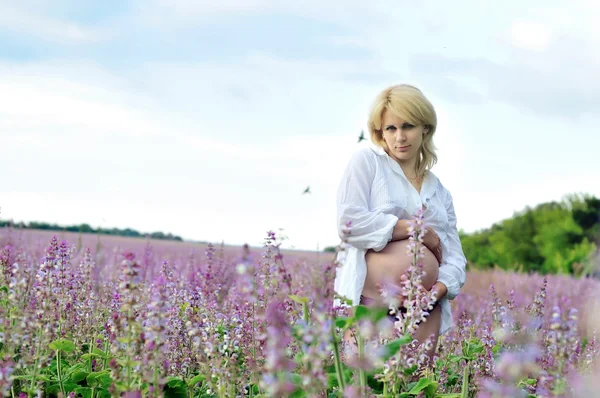 Беременная женщина в поле — стоковое фото