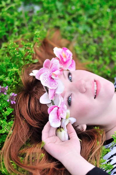 Flicka med orkidé i hår — Stockfoto