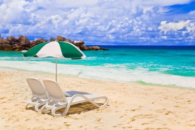 Chairs and umbrella at tropical beach clipart