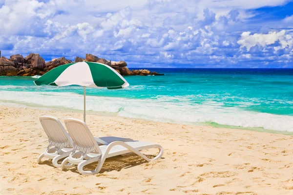 Liegestühle und Sonnenschirm am tropischen Strand — Stockfoto