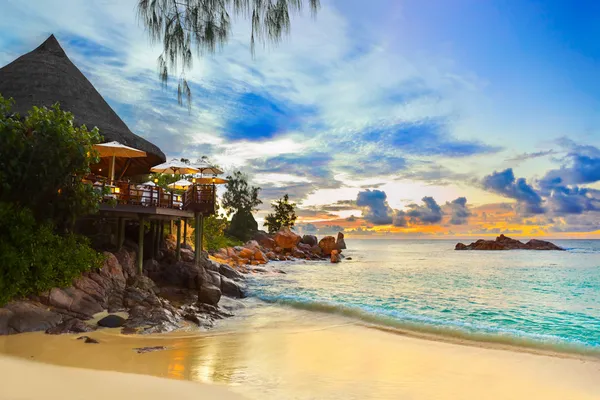 Cafe on tropical beach at sunset — Stock Photo, Image