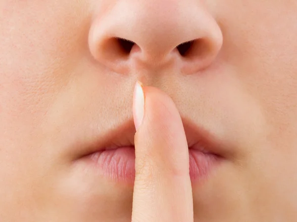 Woman holding finger to lips — Stock Photo, Image
