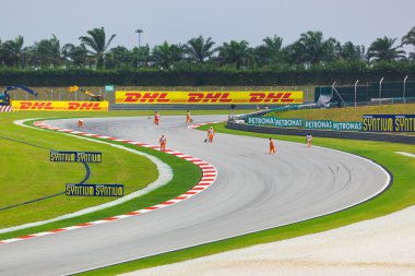 SEPANG, MALAYSIA - APRIL 9: Marshals clean track for qualificati clipart