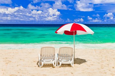 Chairs and umbrella at tropical beach clipart