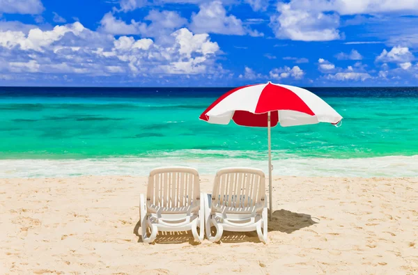 Стулья и зонтик на тропическом пляже — стоковое фото