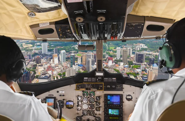 Pilotos en la cabina del avión y la ciudad — Foto de Stock