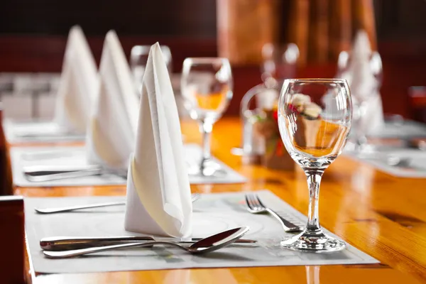 Óculos e pratos na mesa no restaurante Imagem De Stock